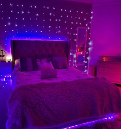 a bed in a room with purple lights on the headboard and foot board,