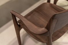 a wooden chair sitting on top of a white and gray floor next to a wall