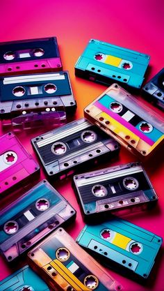 a pile of cassette tapes sitting on top of a pink and blue table next to each other