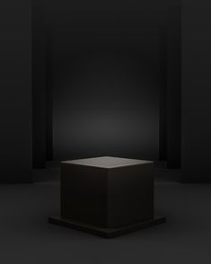 an empty black box in the middle of a dark room with light coming from it