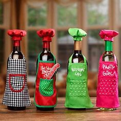 four wine bottles are lined up in the shape of kitchen utensils, one with an oven mitt on top