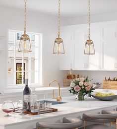 a kitchen with white cabinets and marble counter tops, two pendant lights hanging over the island