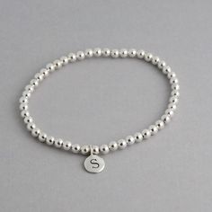 This is my new go to bracelet. Made for easy wear with high quality stretchy cord. Sterling silver or 14k gold fill 4mm beads and a sterling or Italian bronze initial charm. Wear it alone or layered up! So cute. Listing is for one bracelet. I highly recommend measuring your wrist with a tape measure or string and then add up to 1/2 inch for comfort. **Please leave initial choice in notes at checkout** Comes in a Organza bag, gift box available or additional $2 To order additional Initials please Sterling Silver Charm Bracelet With Round Beads For Everyday, Adjustable Sterling Silver Stretch Bracelet For Everyday, Silver Hypoallergenic Stretch Bracelet For Everyday, Silver Name Bracelet With Round Beads For Everyday, Everyday Silver Name Bracelet With Round Beads, Everyday Sterling Silver Stackable Stretch Bracelet, Everyday Stackable Sterling Silver Stretch Bracelet, Everyday Stackable Sterling Silver Bracelet, Initial Charm Bracelet