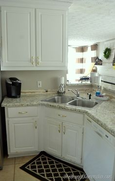 a kitchen with white cabinets and granite counter tops