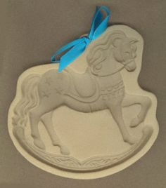 a cookie shaped like a horse with a blue ribbon