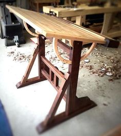 a wooden table sitting on top of a floor next to a blue chair in a room