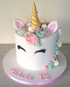 a birthday cake decorated with an unicorn's head and flowers