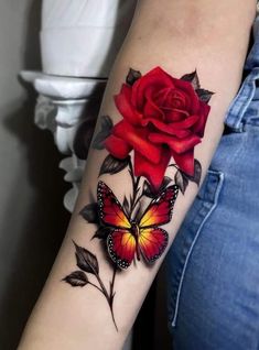 a woman's arm with a red rose and butterfly tattoo on the left forearm