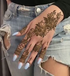 a woman's hand with henna tattoos on her left arm and the bottom half of