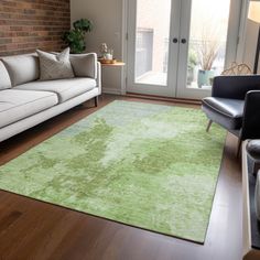 a living room filled with furniture and a green rug on top of a hard wood floor