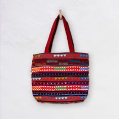 The Akha-Ani large tote bag is the perfect everyday cotton carry-all. It's generous size is designed to hold all the essentials or a lot...! The decoration on the exterior of the bag is hand crafted by the Akha people who live in the hills of  Myanmar. The pattern is colourful and embroidered with different coloured fabrics and threads. *  Bag 46cm Wide x 40cm Depth *  27cm handles *  Inside Bag large open pocket 21cm X 21cm *  Inside zippered pocket 21cm X 21cm *  Also Drawstring compartment in middle of bag *  Cotton with woollen and cotton embroidery *  Padded Base *  Select from a range of woven colour variations Care: Dry Clean only Made in Burma | Fair Trade Disclaimer: Mingalaba products are all made by individual artisans. Each Bag is unique and it's very rare we see 2 perfectly id Rectangular Bag With Woven Motifs For Daily Use, Rectangular Bags With Woven Motifs For Daily Use, Traditional Everyday Tote Bag, Everyday Traditional Tote Bag, Traditional Rectangular Everyday Bag, Traditional Everyday Rectangular Bag, Red Square Canvas Bag With Large Capacity, Large Capacity Red Square Canvas Bag, Traditional Tote Beach Bag For Everyday Use