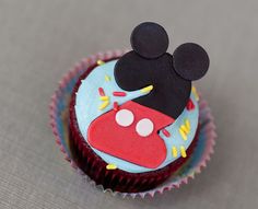 a mickey mouse cupcake sitting on top of a table