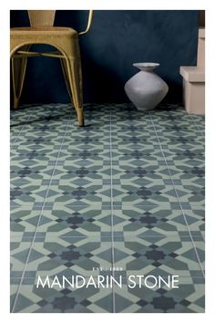 a chair sitting on top of a tiled floor next to a white vase and toilet