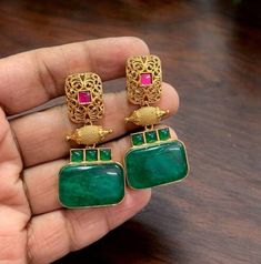 Green Kundan Polki stud earrings, inspired by Sabyasachi, feature emerald doublets and Moissanite Polki diamonds. Gold-plated and designed as statement jewelry, they exude opulence and elegance. Perfect for special occasions, these designer pieces reflect the rich heritage of Indian craftsmanship and add a touch of luxury to any outfit. *𝐏𝐑𝐎𝐃𝐔𝐂𝐓 𝐃𝐄𝐓𝐀𝐈𝐋* * Material: Brass * Plating: Gold Plated * Stone: Semi Precious Emerald Stone & Polki. *𝐃𝐈𝐒𝐂𝐋𝐀𝐈𝐌𝐄𝐑* Product color may sli Indian Gemstone Earrings, Green Emerald Temple Jewelry Earrings, Fusion Style Green Bridal Earrings With Matching Set, Green Fusion Style Bridal Earrings With Matching Set, Green Fusion Style Bridal Matching Earrings, Green Fusion Style Bridal Earrings, Green Gemstone Temple Jewelry Earrings, Festive Temple Jewelry Emerald Earrings, Green Temple Jewelry Bridal Drop Earrings