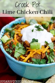 this crockpot lime chicken chili is loaded with shredded cheese, sour cream and cilantro