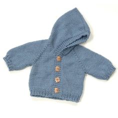 a blue knitted jacket with buttons on the front and back, sitting on a white surface