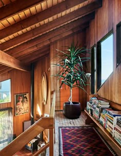 a living room with wooden walls and a plant in the corner on the far wall