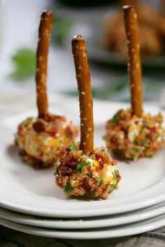 three appetizers on a white plate with green garnish