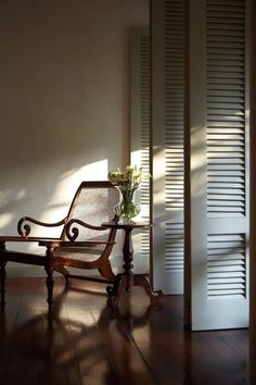 a wooden bench sitting on top of a hard wood floor next to a white wall