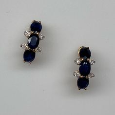 They Have Never Been Worn And Still Have The Original $516 Tags With Them. Set In A Line Down The Front Of The Earring Are Three Natural Matching Oval Shape Sapphires. The Sapphires Measure 4 X 3mm Each And Have A Medium/Dark Blue Color. They Are Set With Shared Prongs And Are Separated By A Small Natural White Diamond On Each Side. The Total Diamond Weight Is 0.08ct Twt. These Earrings Measures 7/16" From Top To Bottom. The Settings Have Stud Posts And Come With Friction Push Backings. They Cur Oval Gemstone Accented Earrings For Formal Occasions, Elegant Oval Multi-stone Earrings, Oval Earrings With Gemstone Accents For Formal Occasions, Oval Sapphire Earrings With 17 Jewels, Elegant Blue Earrings With Stones, Blue Gemstone Accented Earrings For Formal Occasions, Blue Gemstone Accented Earrings For Formal Events, Blue Gemstone-accented Earrings For Formal Occasions, Formal Blue Earrings With Gemstone Accents