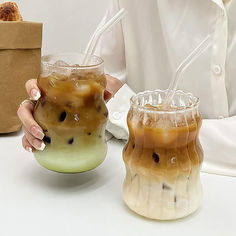 two iced drinks in plastic cups with straws