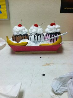 three ice cream sundaes sitting on top of a boat