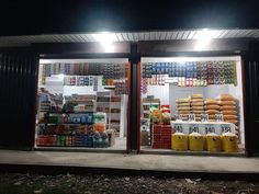 a store front with food on display in the window at night, and lit up by street lights