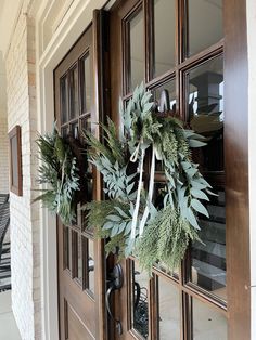 a wreath hanging on the front door of a house