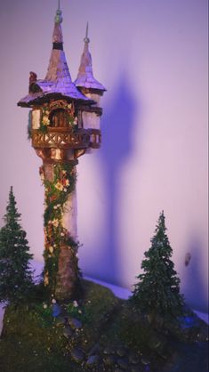 a tall tower with a clock on top of it next to some trees and rocks