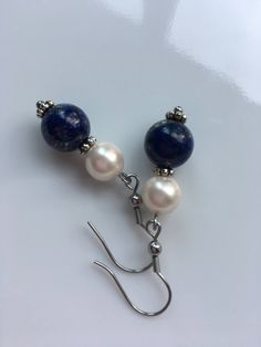 "A 10mm Lapis lazuli gemstone with 8mm ivory shell pearls, this earrings about 2\" long top to bottom, and it's made with stainless steel Hypoallergenic. Hand made jewelry." Blue Sterling Silver Pearl Earrings As Gift, Nickel-free Blue Pearl Earrings Gift, Handmade Blue Pearl Earrings, Blue Pearl Dangle Earrings, Elegant Blue Pearl Earrings With Natural Stones, Round Pearl Earrings, Pearl Earrings Dangle, Hand Made Jewelry, Blue Beads