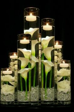 several vases with flowers and candles in them