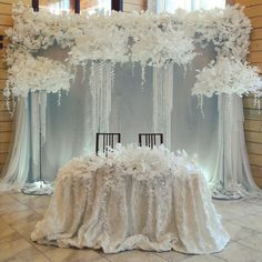 the table is covered with white flowers and draping