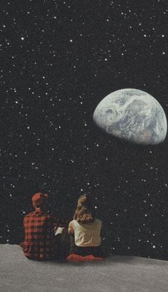 two people sitting on the moon looking at the earth