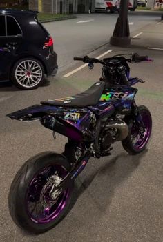 a purple and black motorcycle parked on the street