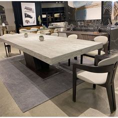 a table and chairs in a room with rugs on the floor next to it