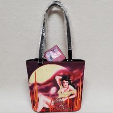 Vintage Deadstock Forelle Cinema Collection Popart Multi-Color Handbag Purse. This Is An Amazing Vintage Deadstock, New With Tag, Purse By Forelle Of A Beautiful Gun Slinging Actress. Brightly Colored With A Gorgeous Actress Toting And Revolver, Wearing A Super Low Cut Dress Covered In Sequins And Surrounded By Fire. Same Photo On Back Without Sequins. Medium Size Bag With Double Shoulder Handles And Silver Hardware. Inner Lining Of White And Red Stars, Light Yellowing From Age, With A Large Poc Retro Red Bag With Zipper Closure, Retro Bags With Zipper Closure For Gift, Retro Bag With Zipper Closure As Gift, Retro Gift Bag With Zipper Closure, Retro Red Bags With Handles, Retro Red Square Bag, Red Retro Square Bag, Retro Red Bag With Top Carry Handle, Burlap Purse