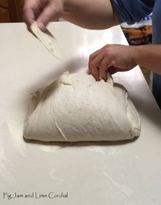 a person is kneading dough on a counter