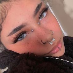 a girl with piercings on her nose and nose ring is looking at the camera