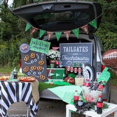 a football themed tailgate party in the back of a van with food and snacks