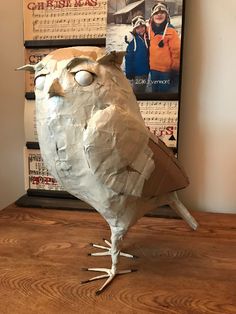 an owl made out of paper on top of a wooden table