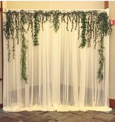 the curtain is covered with green plants and ivys hanging from it's sides