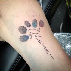 a person with a tattoo on their arm that has a dog's paw and name