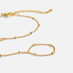 Stylish yet timeless, this stunning 18k gold hand chain with fine beads is for sure a statement piece. Made with waterproof stainless steel, you will never have to worry about fading or tarnishing jewelry ever again. Waterproof & tarnish-free Stainless steel 18K gold plated Bracelet length: 6in (+ 2in adjustable) Fits ring size US6-8 Ring chain: 2in US/Canada Ring Size UK/AU Ring Size Inside Diameter (mm) 6 L 16.6mm 7 N 17.2mm 8 P 18.1mm If you aren't in LOVE with your purchase, please let us kn Gold Adjustable Ball Chain Bracelet, Adjustable Gold Bracelet With Beaded Chain, Gold Ball Chain Bracelet Gift, Adjustable Gold Beaded Chain Bracelet, Adjustable Gold Plated Satellite Chain Bracelet, Adjustable Gold Beaded Bracelet With Satellite Chain, Gold Metal Bracelet With Ball Chain, Minimalist Gold Bracelet With Ball Chain, Adjustable Gold Ball Chain Jewelry