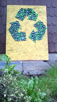 a yellow and green sign sitting on the side of a building next to some grass