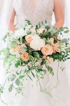 a bridal holding a bouquet of flowers and greenery