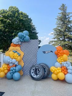 an assortment of balloons on display in front of a sign