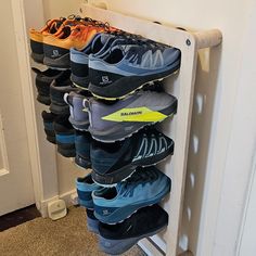 there are many pairs of running shoes on the rack in this room, all lined up and ready to go