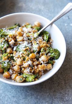 a bowl filled with broccoli and chickpeas covered in parmesan cheese