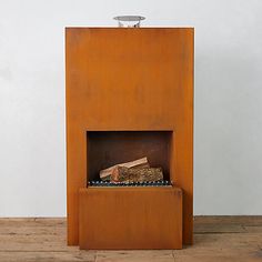 a fire place sitting on top of a hard wood floor next to a white wall