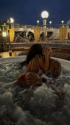 a woman in a hot tub at night with her hands on her face and eyes closed